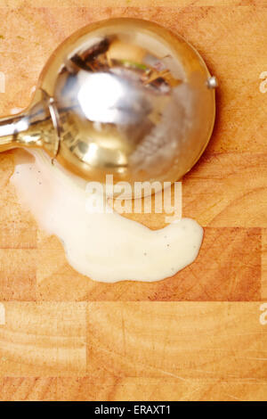 La crème glacée disher avec glace vanille fondu sur une planche en bois Banque D'Images