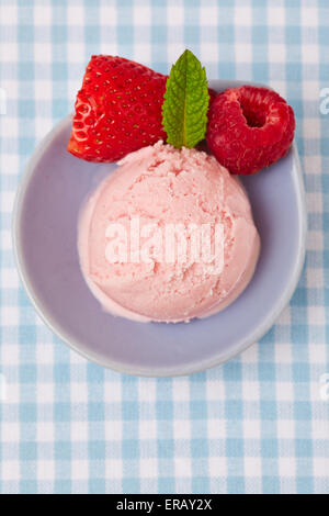 Boule de glace à la fraise avec de la fraise et de la framboise au-dessus Banque D'Images