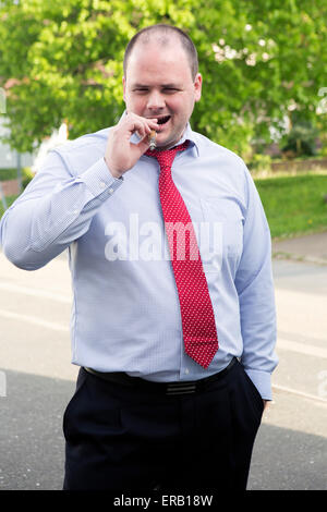 L'homme en chemise et cravate fumer un cigare Banque D'Images