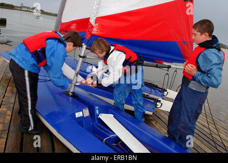 Les jeunes de la décolleteuse de voile dériveurs à Hengistbury Head Centre, Dorset. Un bateau britannique à l'eau bateaux canot sports loisirs sport Banque D'Images