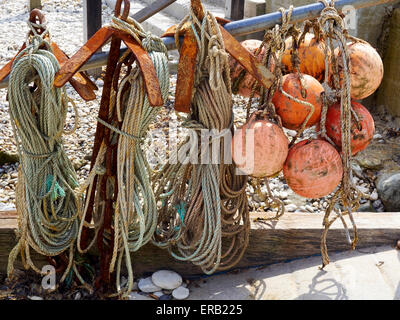 Rouleaux de corde usée et flotteurs de pêche utilisé par un pêcheur côtier se suspendre à un rail à Crique de Lulworth. Banque D'Images