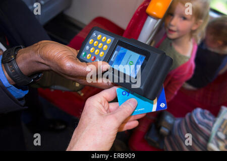 Inspector vérifie / lit carte Oyster ticket avec reader sur SW Trains train aérien également valide LT /bus voyage tube souterrain Banque D'Images