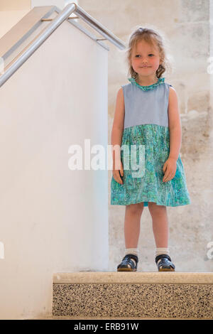 Enfant, 3 fillette de trois ans, jeune garçon, envisage de descendre les escaliers en cas d'escalier / un bâtiment avec le mur (élevés) Bannister Banque D'Images