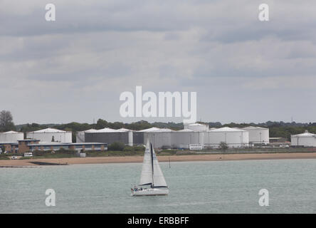 Un yacht de voile passé BP Oil terminal à Hamble le riz Banque D'Images