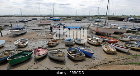 Voiliers avec la marée sur l'estuaire Leigh on Sea Essex UK. L'homme est la peinture de son bateau. Banque D'Images