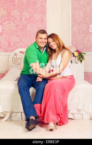 Senior couple sitting on sofa dans la chambre rose Banque D'Images