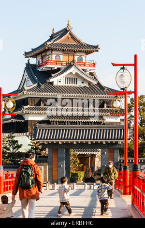 Japon, Nagoya. Reconstruction en béton d'un pont fluvial en bois avec des rampes et des lampes vermilion, menant au château de Kiyosu avec fond bleu ciel. Banque D'Images