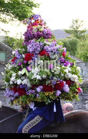 Portant une coiffe de fleurs, le Roi Garland par parades Castleton dans le Peak District pour célébrer le Jour de la pomme de chêne UK Banque D'Images