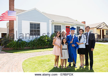 Portrait smiling graduate multi-generation family front yard