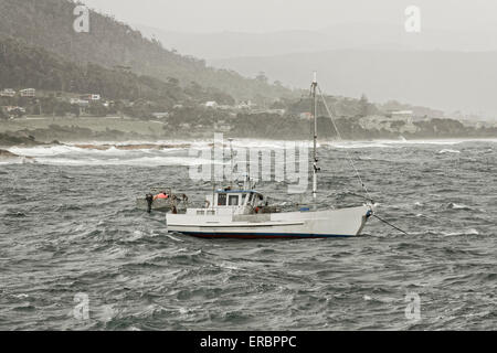 Bateau de pêche par gros temps amarré près de la plage Banque D'Images