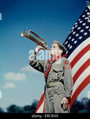 Années 1950, boy-scout SOUFFLANT BUGLE EN FACE DE 48 étoiles du drapeau américain Banque D'Images