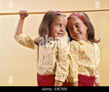 1960 LITS POUR MESURER LEUR HAUTEUR AVEC GUIDE SUR LEURS TÊTES Banque D'Images