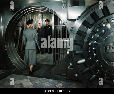 Années 1940 Années 1950 FEMME MARCHE DANS PRIVATE BANK VAULT caissier de banque ET DE GARDE EN COFFRE-FORT Banque D'Images