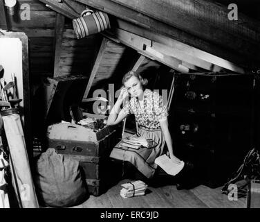 Années 1930 Années 1940 DÉSEMPARÉ À LA JEUNE FEMME DANS LE GRENIER LA LECTURE DE LETTRES ANCIENNES Banque D'Images