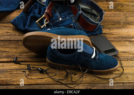 Bleu foncé des chaussures d'hommes, jeans, smartphone et accessoires sur fond de bois Banque D'Images