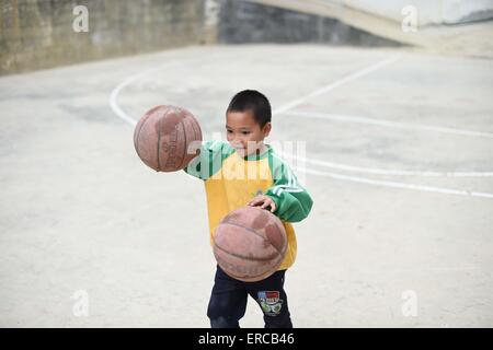 (150601) -- "LIUTONG, le 1 er juin 2015 (Xinhua) -- un élève joue au basketball à l'école élémentaire en Nongyong Bansheng Canton de "Liutong Yao comté autonome, 27 janvier 2015. Le 1 juin marque la Journée internationale des enfants. (Xinhua/Huang Xiaobang) (lfj) Banque D'Images