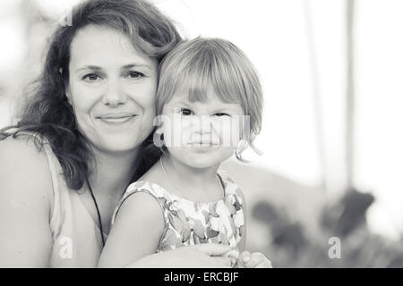 De l'extérieur une véritable famille caucasienne, jeune mère avec sa petite fille mignonne Banque D'Images