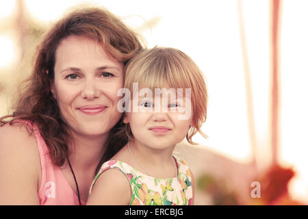 Une soirée d'un véritable portrait de famille caucasienne, jeune mère avec sa petite fille mignonne, photo aux teintes chaleureuses, ancien sty Banque D'Images