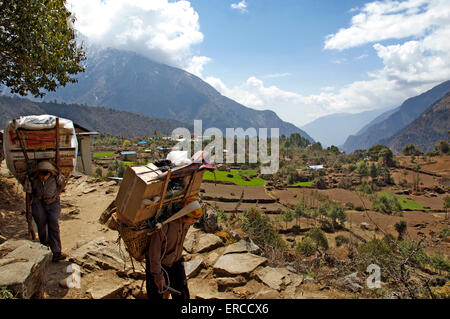 Deux porteurs népalais lourdement chargée sur la route de Lukla à Namche Bazar dans la région de Khumbu. Banque D'Images