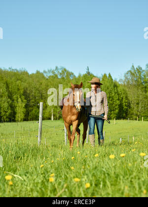 Cowgirl et poney ensemble, belle journée d'été ensoleillée Banque D'Images