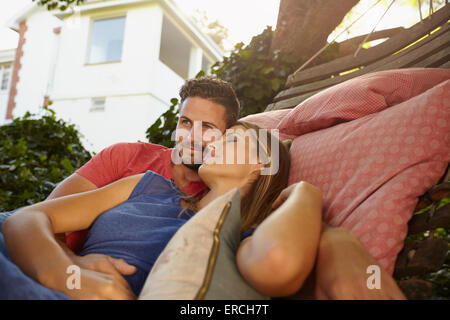 Apprécier et aimer couple sur un hamac ensemble. Jeune homme à la voiture et la femme avec les yeux fermés en th Banque D'Images