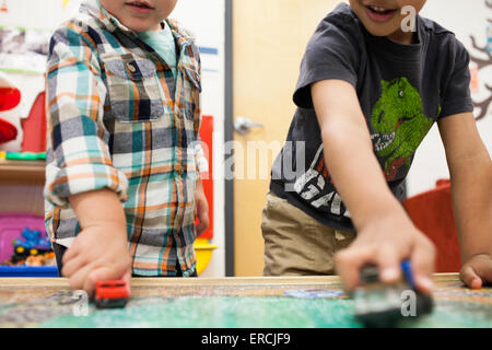 Deux jeunes garçons jouer avec des petites voitures. Banque D'Images