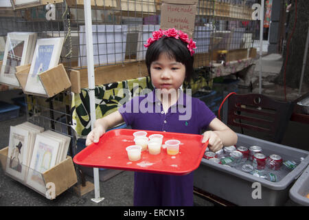 Jeune fille donne des échantillons de limonade maison à ses parents lors d'une concession alimentaire foire de rue à Brooklyn, New York. Banque D'Images