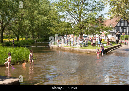 La moitié des vacances d'été paresseux comme beaucoup d'enfants de parents à long terme pagaie et pêcher dans la rivière Darent au croisement de Ford Eynesford Banque D'Images