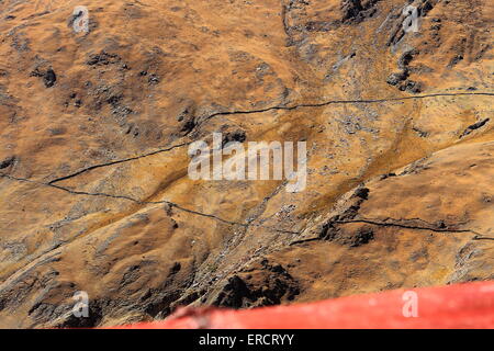 Les yacks comme petits points noirs au pâturage le pâturage sur la montagne en face de la Drak Yerpa monast.-complexe de grottes. Tibet Banque D'Images