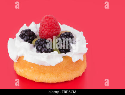 Les framboises, Kiwi, framboise et crème fouettée topping un dessert shell, sur fond rouge Banque D'Images
