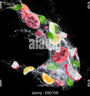 Fruits frais avec de l'eau splash sur fond sombre Banque D'Images