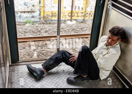 Mumbai Inde,Mumbai Central local Railway Station,Western Line,train,rider,passagers rider riders,porte ouverte,homme hommes,snoozing,dormir, Banque D'Images