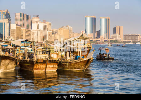 À l'ancienne, traditionnelles boutres arabes amarré à quai à Deira, Dubaï Creek, ÉMIRATS ARABES UNIS, avec les gratte-ciel modernes derrière Banque D'Images