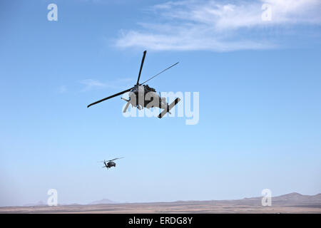 Deux HH-60G Pave Hawk survolant la zone d'entraînement de Playas, Nouveau Mexique, au cours de l'effort Angel 2013. Banque D'Images