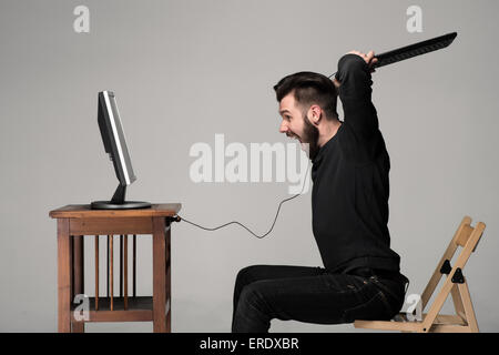 Homme en colère est en train de détruire un clavier Banque D'Images