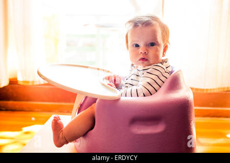 Caucasian baby girl sitting in chaise haute Banque D'Images