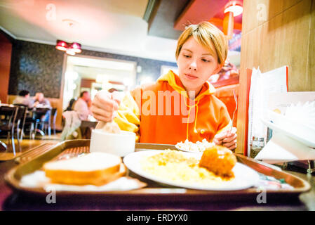 Caucasian woman eating breakfast in cafeteria Banque D'Images