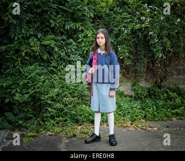 Mixed Race lycéenne en uniforme avec sac à dos Banque D'Images