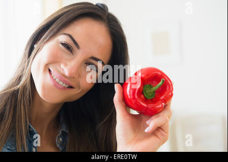 Smiling Caucasian woman holding red pepper Banque D'Images