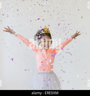 Mixed Race girl wearing tiara throwing confetti Banque D'Images