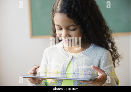 Mixed Race student using digital tablet in classroom Banque D'Images