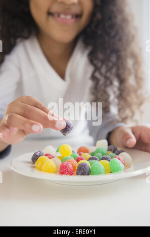 Close up of mixed race girl eating jujubes Banque D'Images