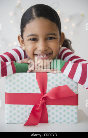 Mixed Race girl smiling with wrapped gift Banque D'Images