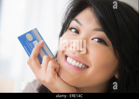 Smiling Caucasian woman holding credit card Banque D'Images