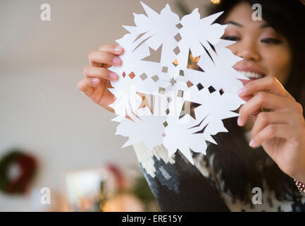 Pacific Islander woman holding paper snowflake Banque D'Images