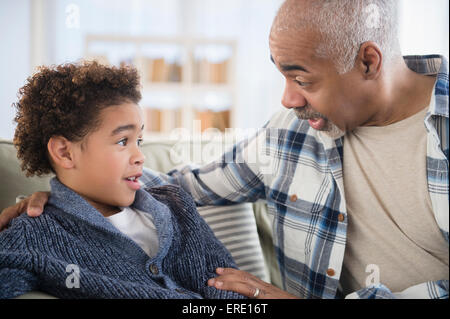 Mixed Race grand-père et petit-fils en conversation sur canapé Banque D'Images