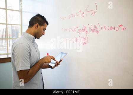 Asian businessman using digital tablet at whiteboard Banque D'Images