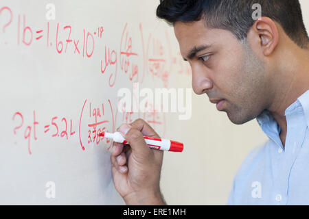 Asian businessman écrit formule sur tableau blanc Banque D'Images