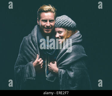 Smiling couple wrapped in blanket Banque D'Images