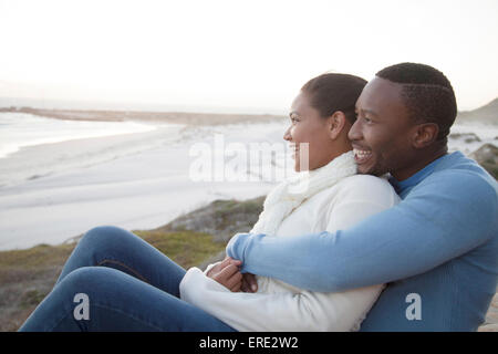 Couple hugging on cliffs sur beach Banque D'Images